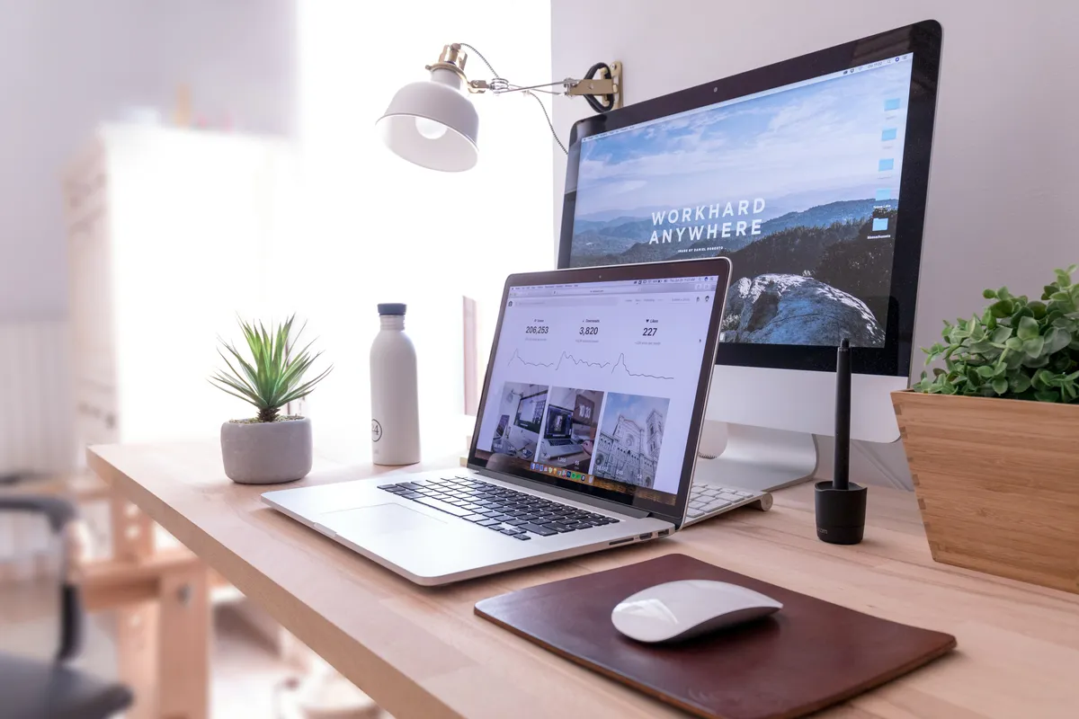 Modern workspace with dual monitors showing website design and analytics
